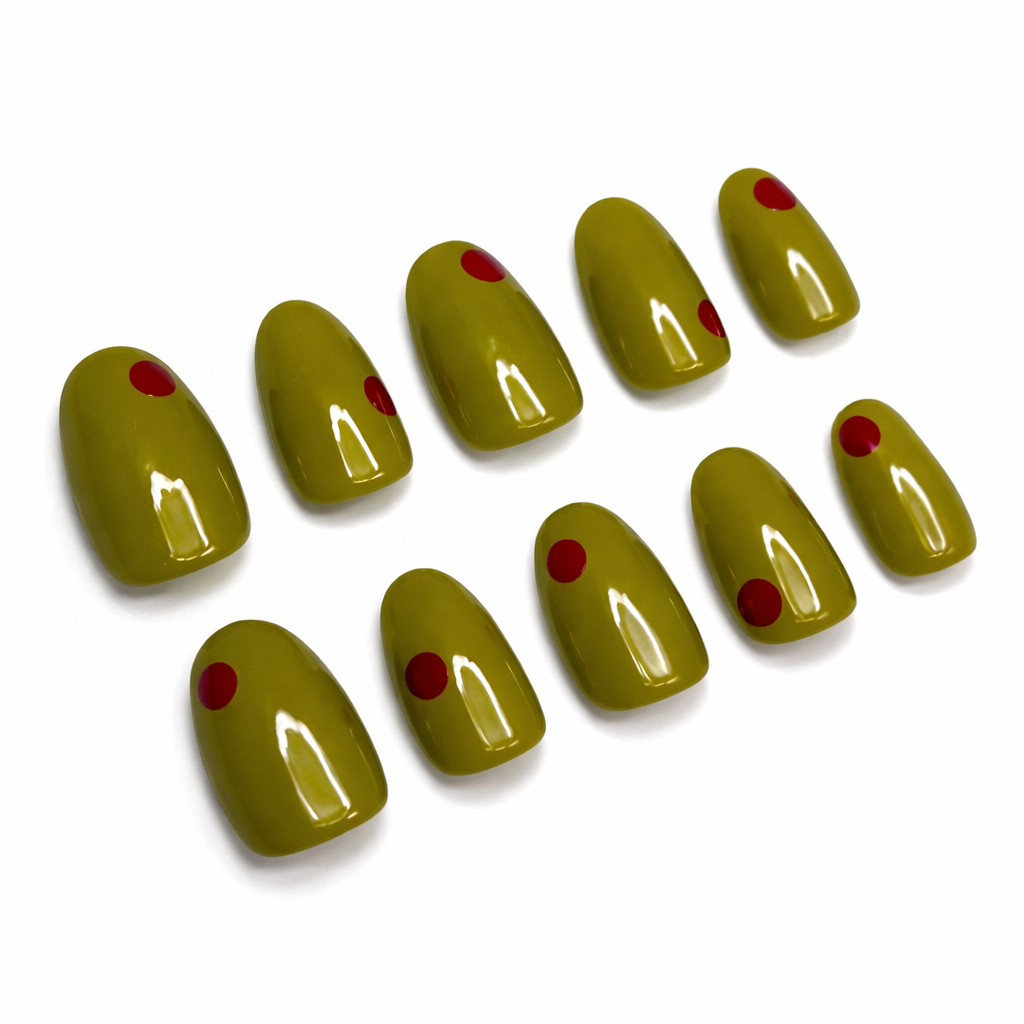 Set of green nail extensions with red dots on a white background